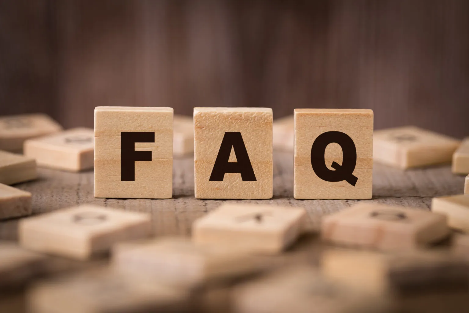 Scritta "FAQ" in legno che indica "Domande frequenti"
