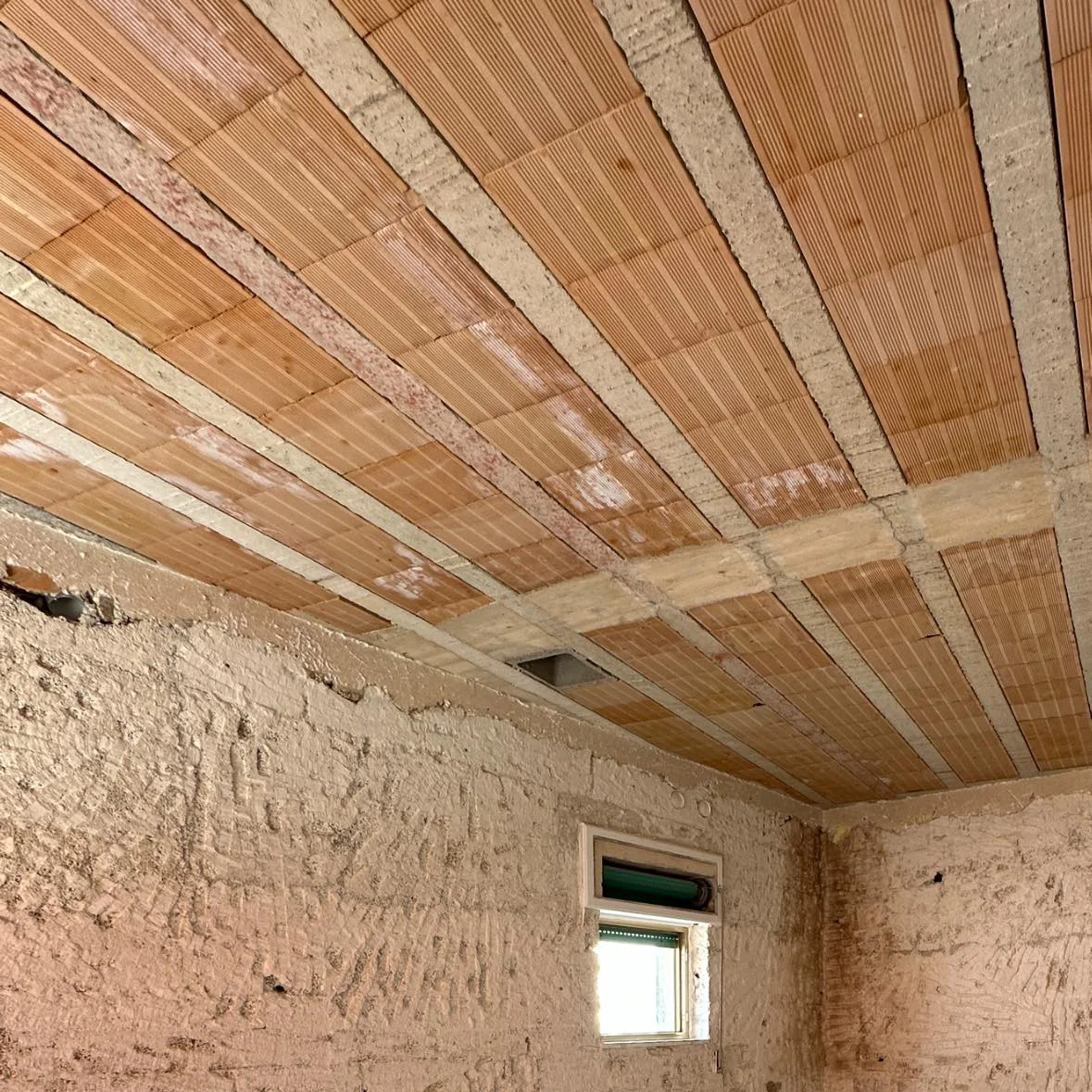 Vista muraria di un soffitto a travetti e pignatte non intonacato che mostra potenziali ponti termici per la formazione della muffa